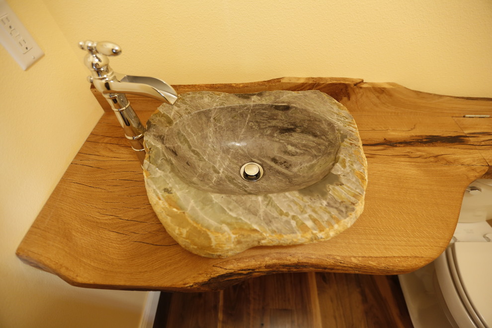 Foto på ett litet rustikt badrum med dusch, med öppna hyllor, skåp i mörkt trä och träbänkskiva