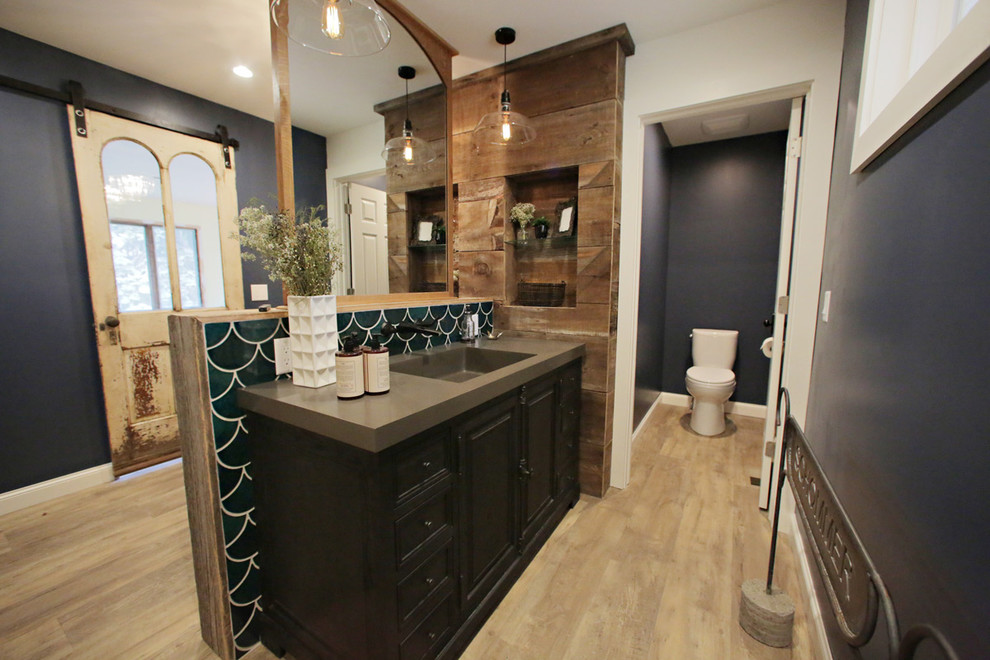 Example of a large mountain style master green tile and ceramic tile light wood floor bathroom design in Minneapolis with louvered cabinets, dark wood cabinets, a one-piece toilet, blue walls, an integrated sink and solid surface countertops