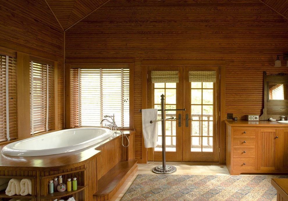 Inspiration for a large rustic ensuite bathroom in Burlington with a built-in sink, beaded cabinets, medium wood cabinets, wooden worktops, a built-in bath, brown walls and light hardwood flooring.