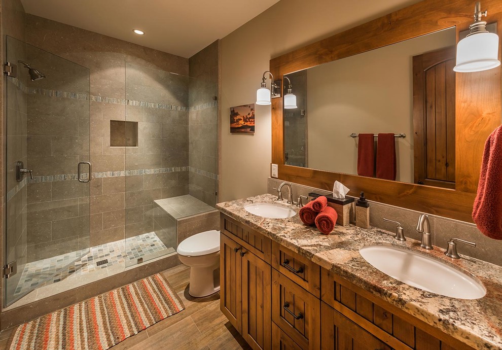 Rustic bathroom in Sacramento with a submerged sink, shaker cabinets, medium wood cabinets, an alcove shower, grey tiles and brown walls.