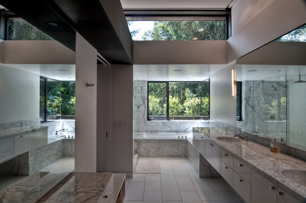 Foto de cuarto de baño contemporáneo con lavabo bajoencimera, armarios con paneles lisos y bañera encastrada sin remate