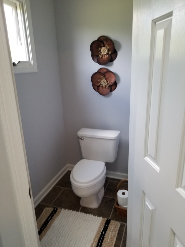 Cette image montre un WC et toilettes chalet en bois vieilli de taille moyenne avec un placard avec porte à panneau encastré, WC séparés, un carrelage noir, des carreaux de céramique, un mur gris, un sol en carrelage de céramique, un lavabo encastré, un plan de toilette en bois, un sol gris et un plan de toilette noir.