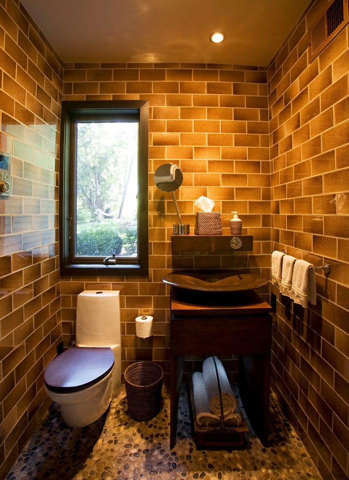 Exempel på ett mellanstort modernt badrum, med ett konsol handfat, skåp i mörkt trä, träbänkskiva, en dubbeldusch, en toalettstol med hel cisternkåpa, släta luckor och klinkergolv i småsten