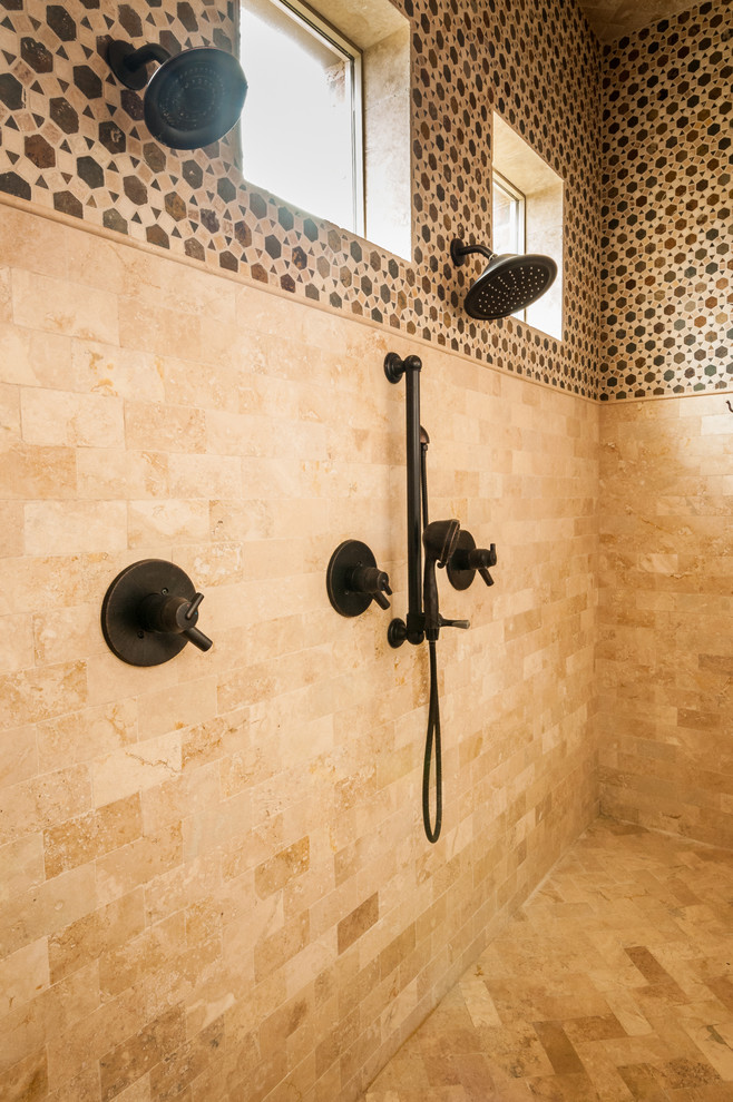 Rustik inredning av ett stort en-suite badrum, med ett undermonterad handfat, släta luckor, vita skåp, marmorbänkskiva, ett fristående badkar, en öppen dusch, en toalettstol med hel cisternkåpa, vit kakel, stenkakel, beige väggar och travertin golv