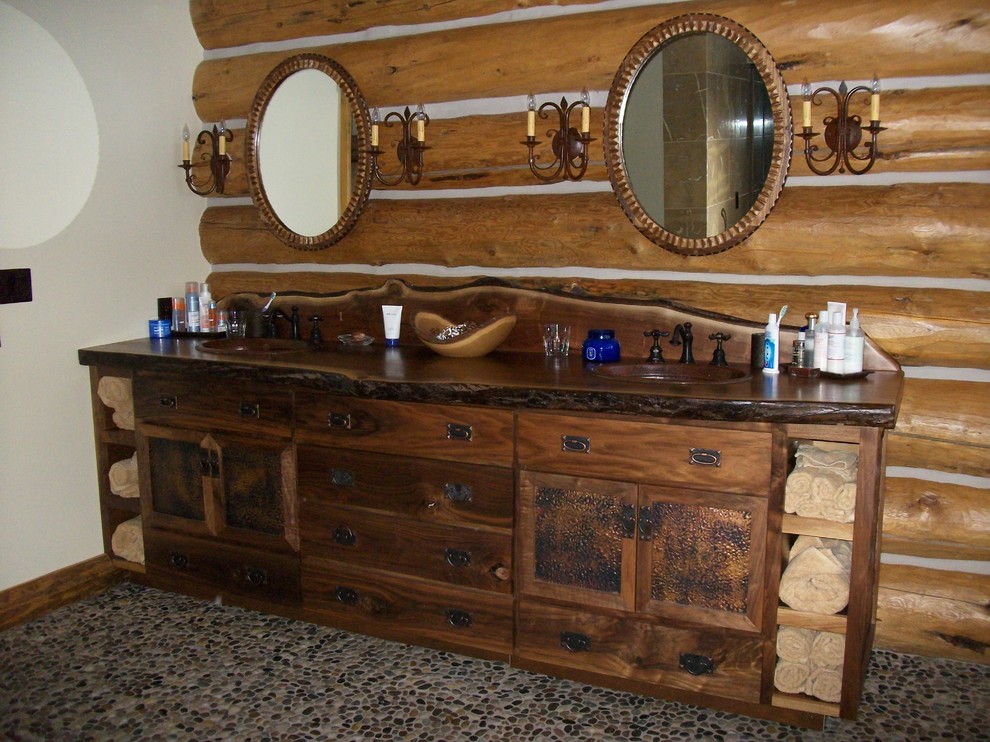 Bild på ett stort rustikt en-suite badrum, med ett nedsänkt handfat, möbel-liknande, skåp i slitet trä, träbänkskiva, ett fristående badkar, grå kakel, bruna väggar och klinkergolv i småsten