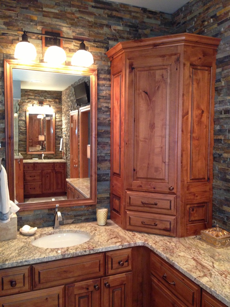 Inspiration pour une salle de bain chalet en bois vieilli avec un placard avec porte à panneau surélevé, un plan de toilette en granite, une baignoire posée et une douche d'angle.