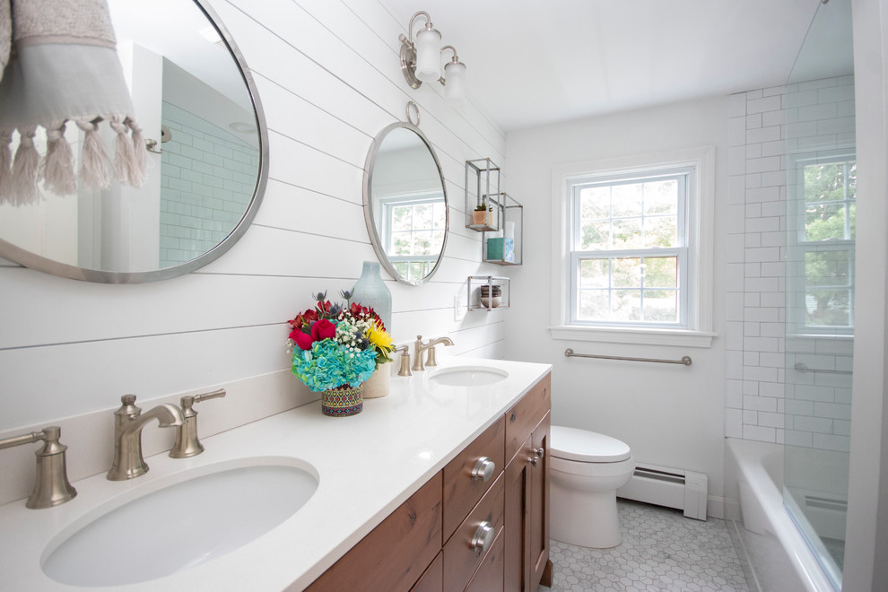 Bathroom - mid-sized farmhouse master white tile and subway tile porcelain tile and white floor bathroom idea in Providence with recessed-panel cabinets, dark wood cabinets, a two-piece toilet, white walls, an undermount sink, quartzite countertops, a hinged shower door and white countertops