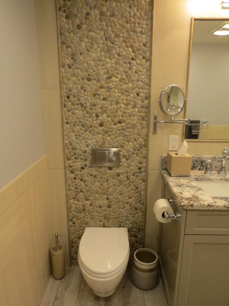 Medium sized traditional ensuite bathroom in Portland Maine with a submerged sink, recessed-panel cabinets, grey cabinets, granite worktops, an alcove shower, a wall mounted toilet, multi-coloured tiles, pebble tiles, blue walls and porcelain flooring.