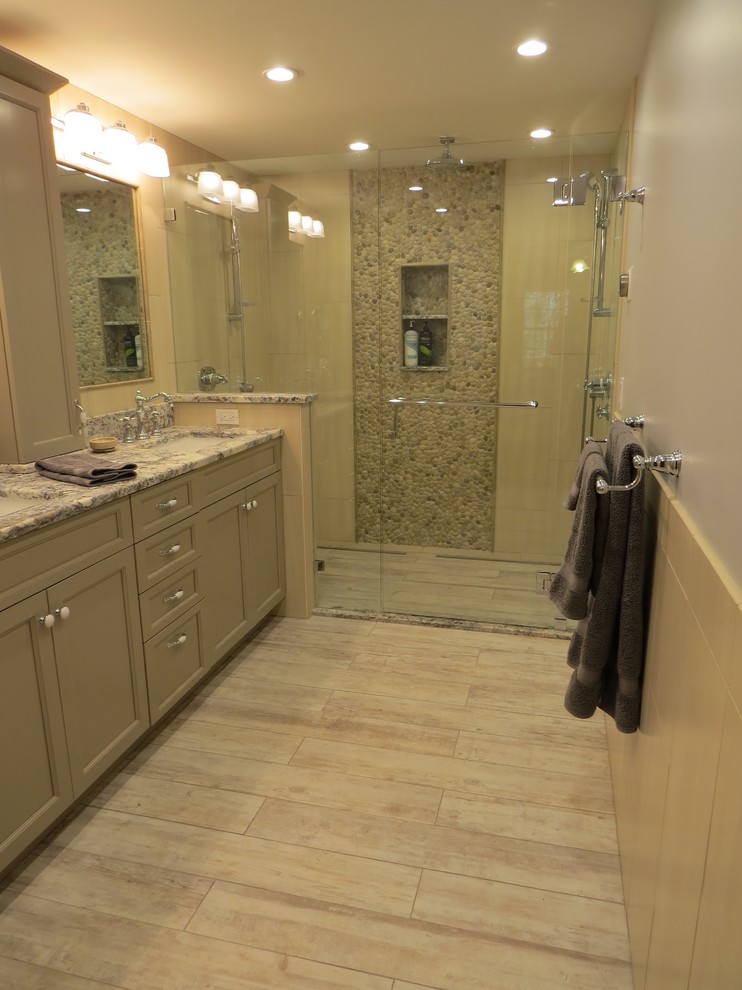 Mid-sized transitional master multicolored tile and pebble tile porcelain tile alcove shower photo in Portland Maine with an undermount sink, recessed-panel cabinets, gray cabinets, granite countertops, a wall-mount toilet and blue walls