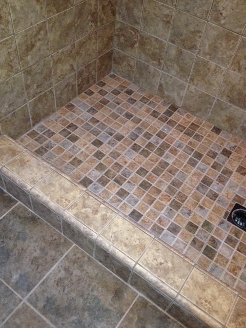 Réalisation d'une salle de bain tradition avec un lavabo posé, un plan de toilette en carrelage, une douche ouverte, un carrelage gris et mosaïque.