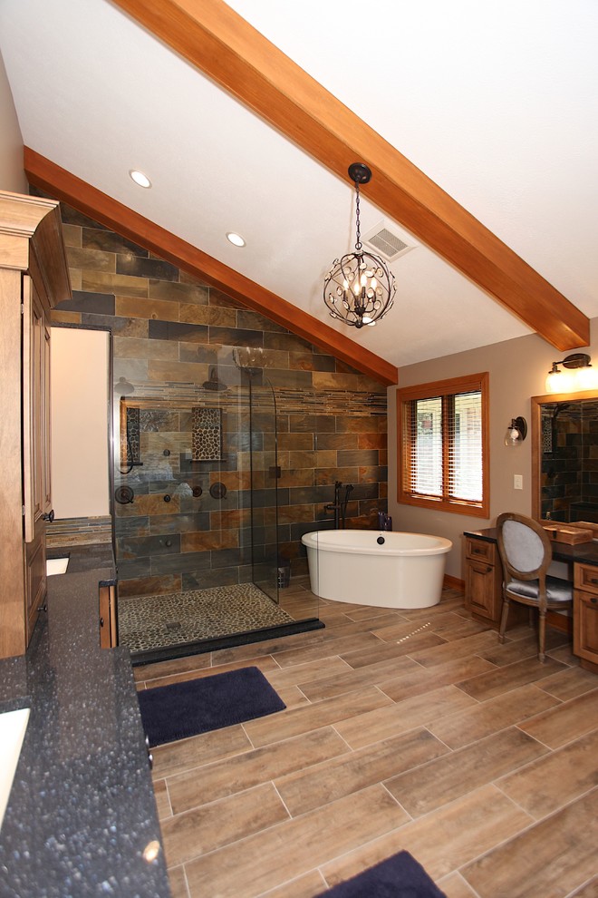 Photo of a large rustic ensuite bathroom in Indianapolis with brown cabinets, a freestanding bath, slate tiles, beige walls, a submerged sink, brown floors and an open shower.