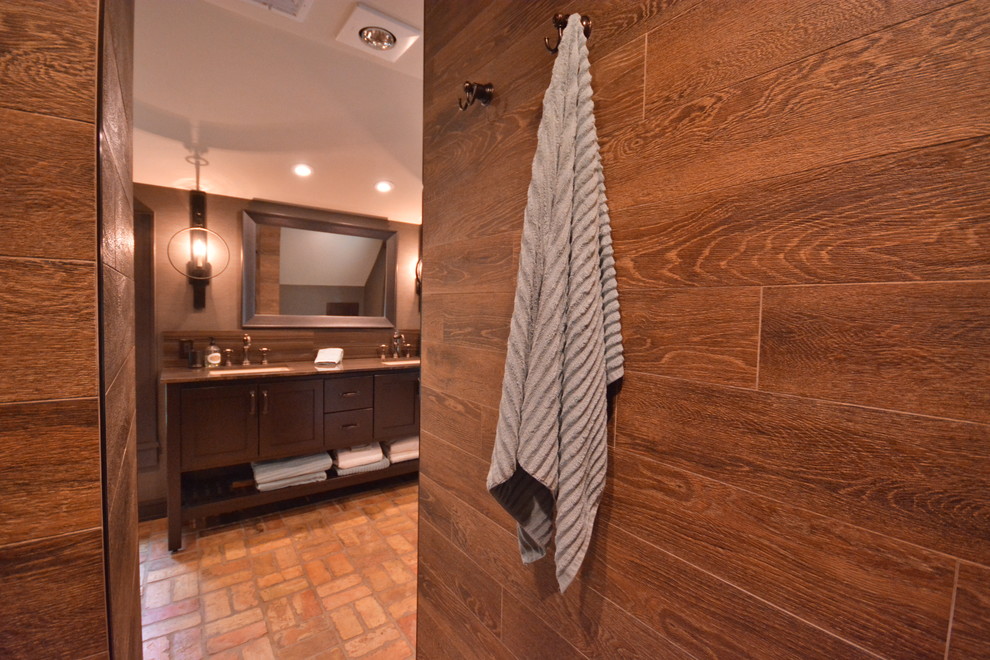 На фото: большая главная ванная комната в стиле рустика с фасадами в стиле шейкер, темными деревянными фасадами, открытым душем, раздельным унитазом, коричневой плиткой, керамогранитной плиткой, коричневыми стенами, кирпичным полом, врезной раковиной, мраморной столешницей, оранжевым полом и открытым душем