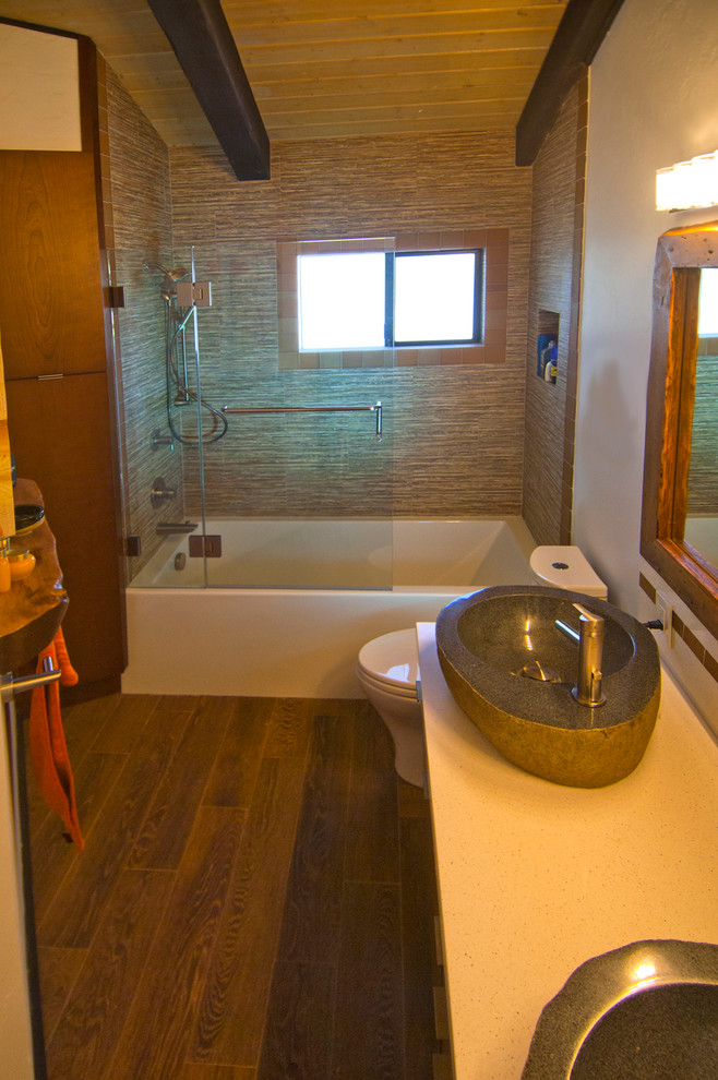 Bild på ett mellanstort funkis badrum, med släta luckor, skåp i mellenmörkt trä, ett badkar i en alkov, en dusch/badkar-kombination, flerfärgad kakel, mosaik, vita väggar, klinkergolv i porslin, ett fristående handfat och bänkskiva i kvartsit
