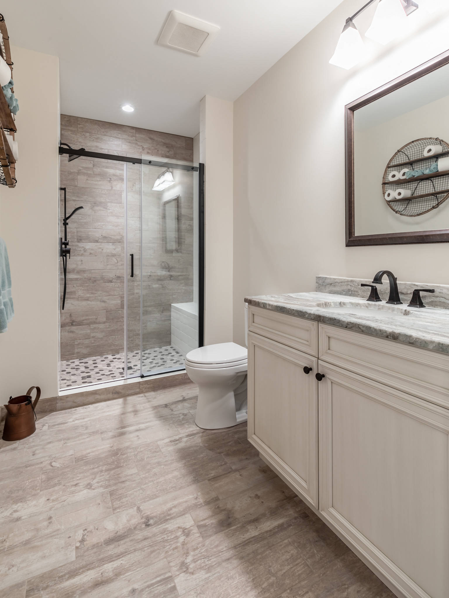 Modern farmhouse bathroom with Taupe cabinets, brass mirrors