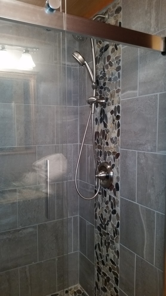 Foto di una stanza da bagno padronale rustica di medie dimensioni con doccia a filo pavimento, piastrelle grigie, pareti marroni, pavimento con piastrelle di ciottoli, pavimento multicolore e porta doccia scorrevole
