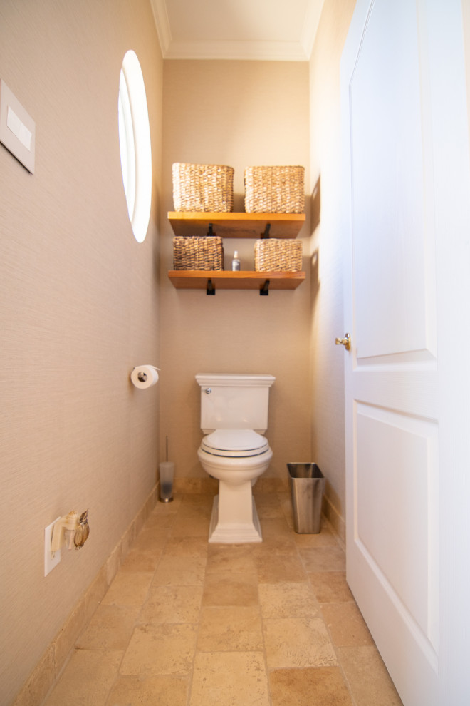 Réalisation d'un grand WC et toilettes méditerranéen en bois vieilli avec un placard sans porte, WC séparés, un carrelage beige, du carrelage en travertin, un mur beige, un sol en travertin, une vasque, un plan de toilette en bois, un sol beige et un plan de toilette marron.