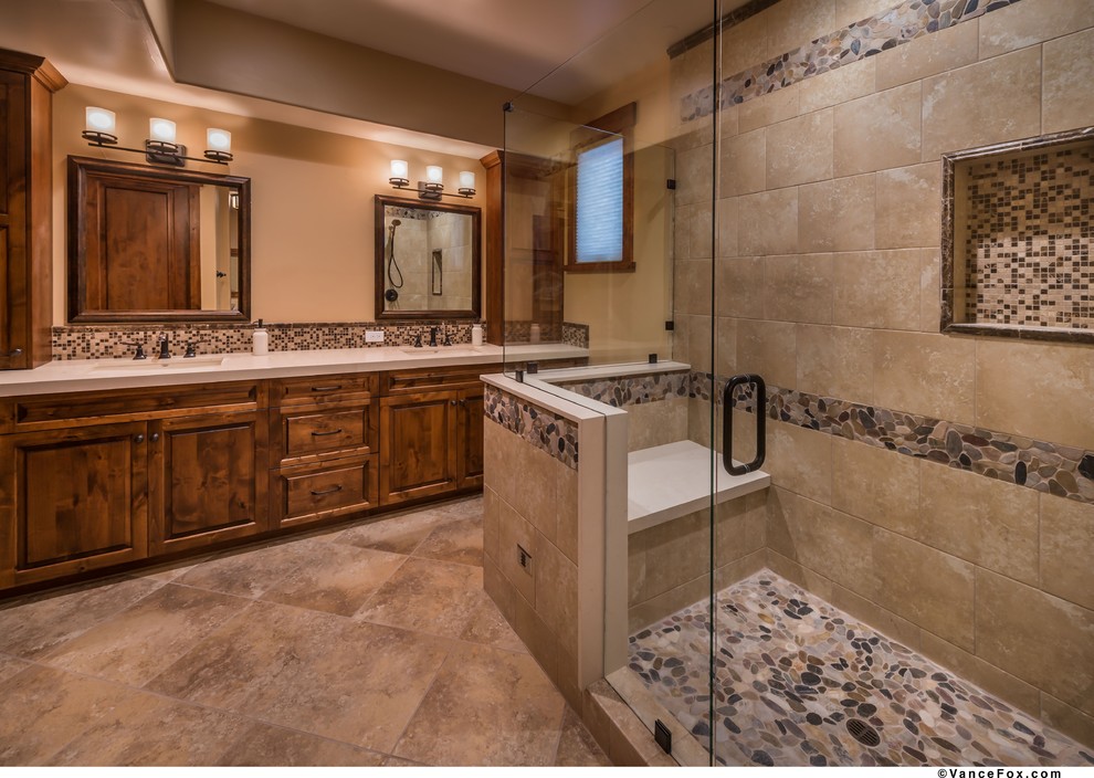 Design ideas for a large rustic ensuite bathroom in Sacramento with raised-panel cabinets, medium wood cabinets, an alcove shower, a two-piece toilet, brown tiles, porcelain tiles, brown walls, porcelain flooring, a submerged sink and engineered stone worktops.