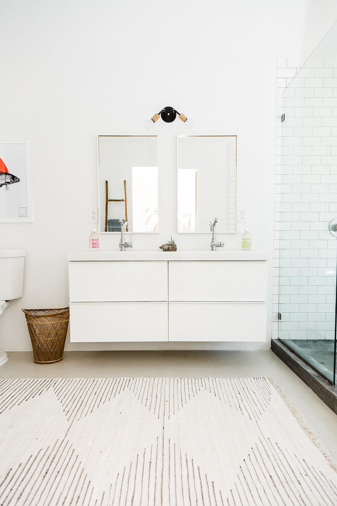 Cette image montre une salle de bain principale sud-ouest américain de taille moyenne avec une baignoire sur pieds, une douche ouverte, WC à poser, un carrelage blanc, un carrelage métro et sol en béton ciré.