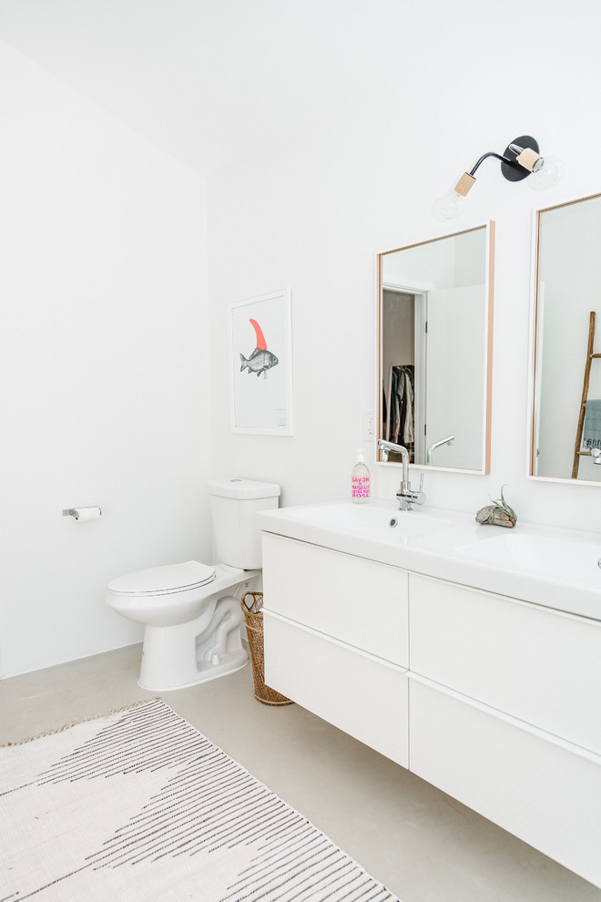 Foto på ett mellanstort funkis en-suite badrum, med vita skåp och betonggolv