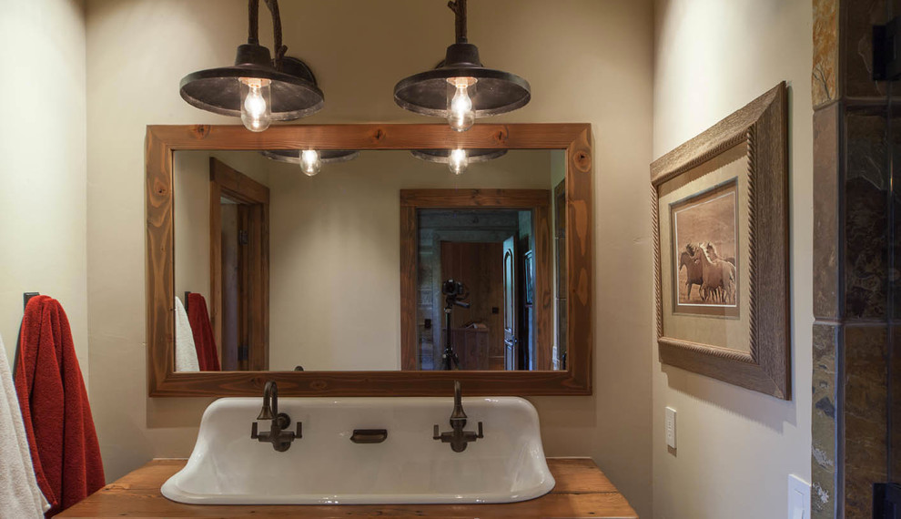 Example of a huge mountain style 3/4 bathroom design in Other with a drop-in sink, open cabinets, distressed cabinets, wood countertops and beige walls