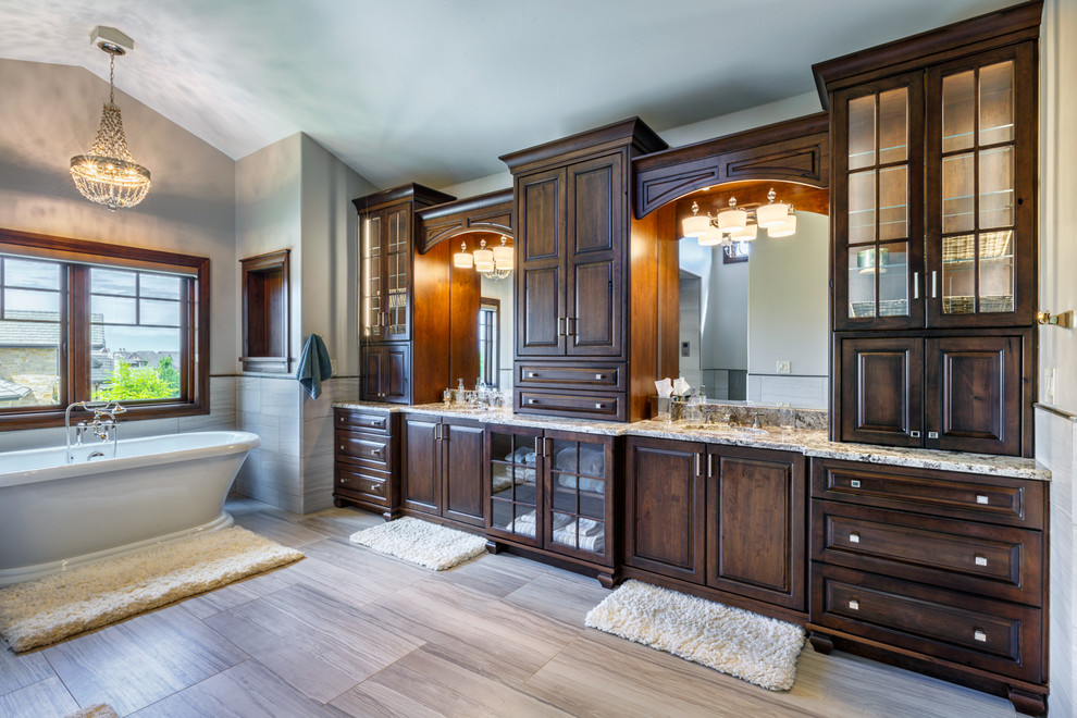 Imagen de cuarto de baño principal rural grande con armarios con paneles con relieve, puertas de armario de madera en tonos medios y bañera exenta