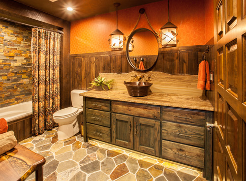 Rustic-style bathroom cabinets with reclaimed wood vanity and stone countertop in a cozy Canadian cottage bathroom