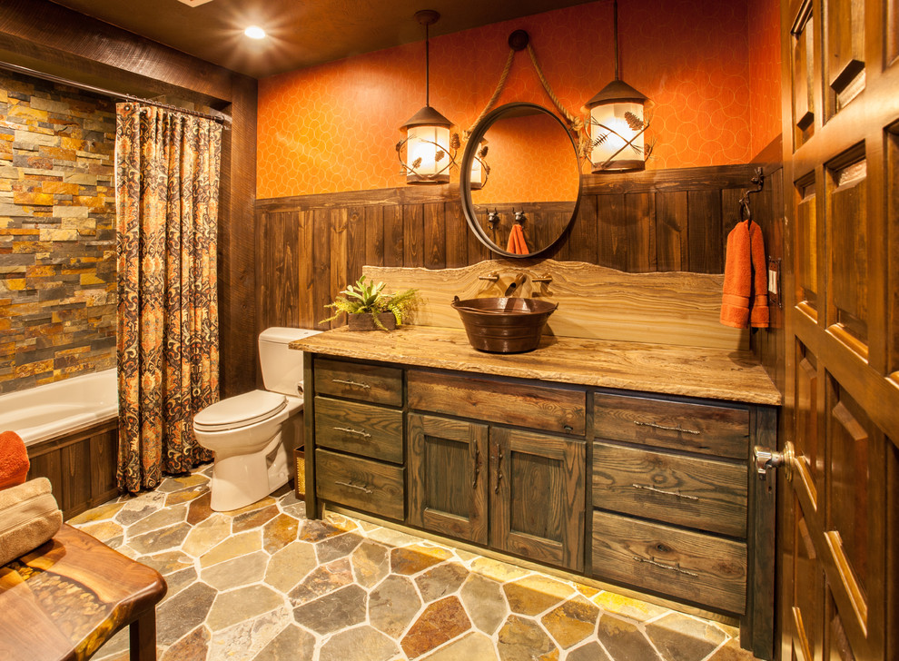 Inspiration för mellanstora rustika badrum, med ett platsbyggt badkar, en dusch/badkar-kombination, en toalettstol med separat cisternkåpa, orange väggar, ett fristående handfat, bänkskiva i kvartsit, skåp i mörkt trä och skåp i shakerstil