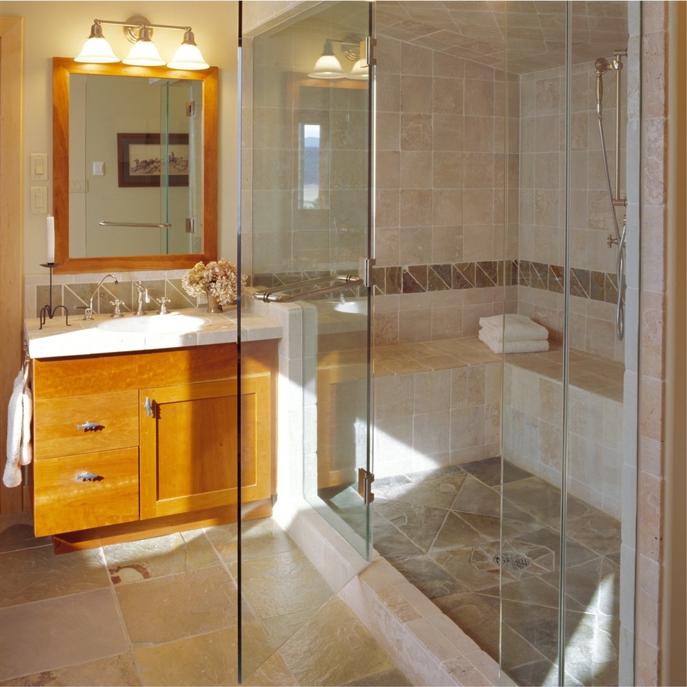 Réalisation d'une douche en alcôve chalet en bois brun avec un lavabo encastré, un placard à porte shaker, un plan de toilette en carrelage et un carrelage beige.