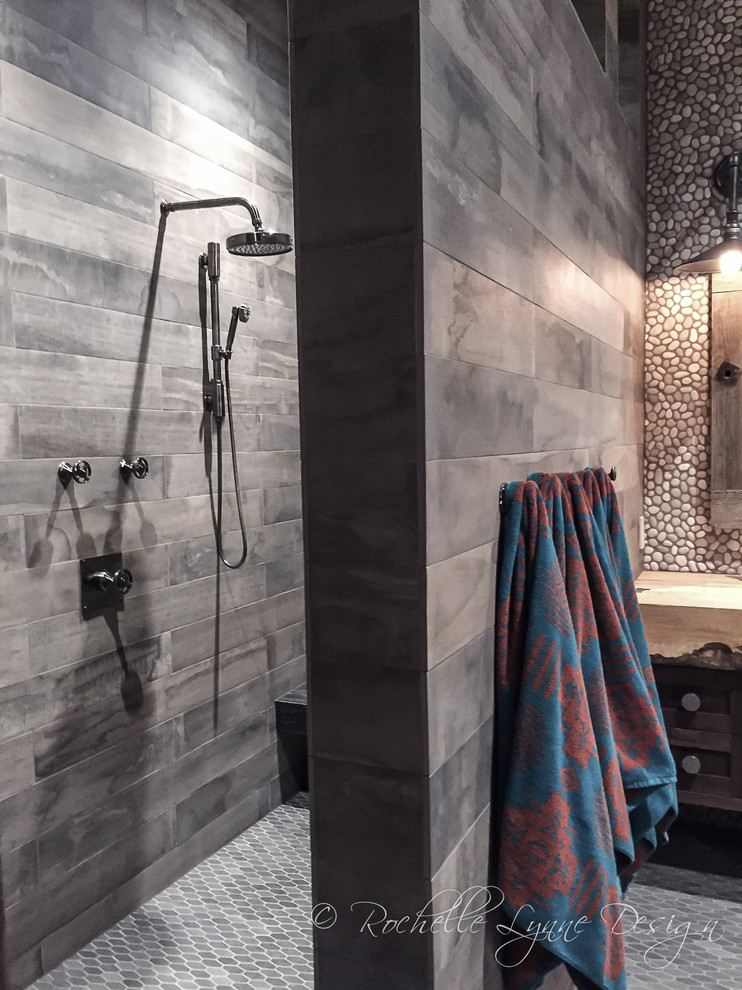 Expansive rustic family bathroom in Calgary with distressed cabinets, a walk-in shower, multi-coloured tiles, pebble tiles, mosaic tile flooring, wooden worktops and shaker cabinets.