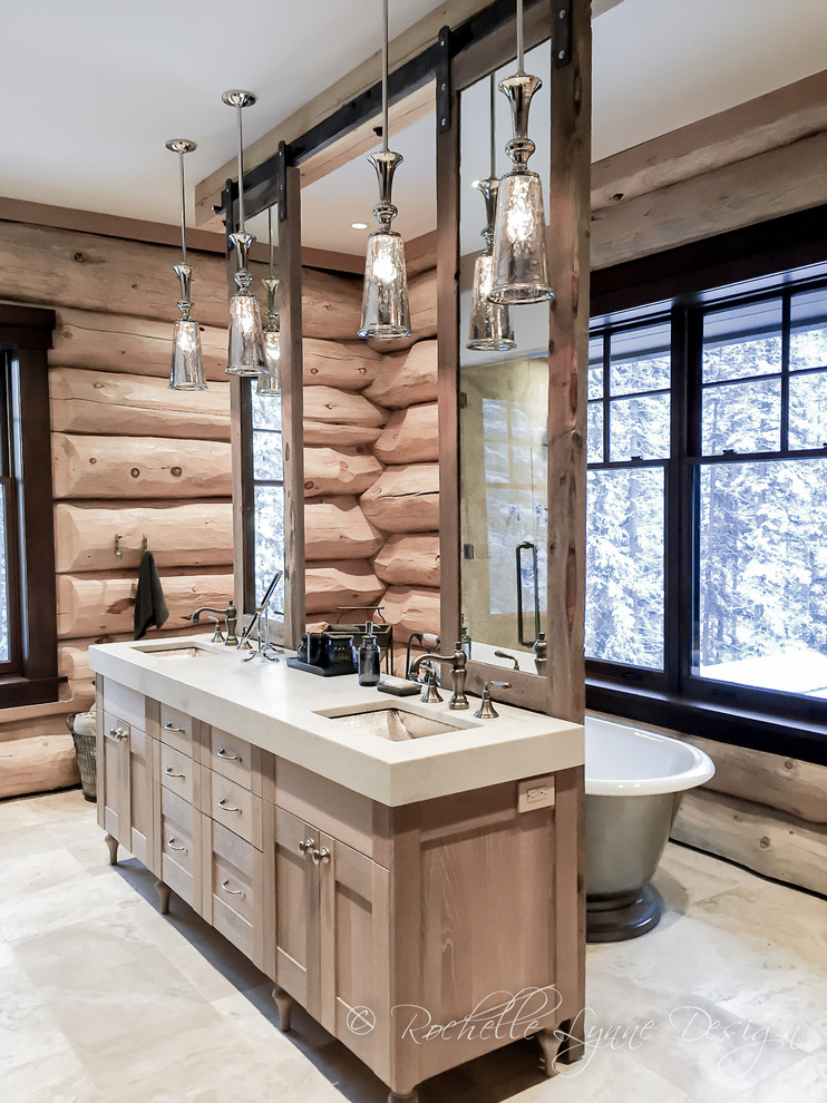 Immagine di una grande stanza da bagno padronale stile rurale con ante in stile shaker, ante in legno chiaro, vasca freestanding, pavimento in travertino, lavabo sottopiano e top in granito