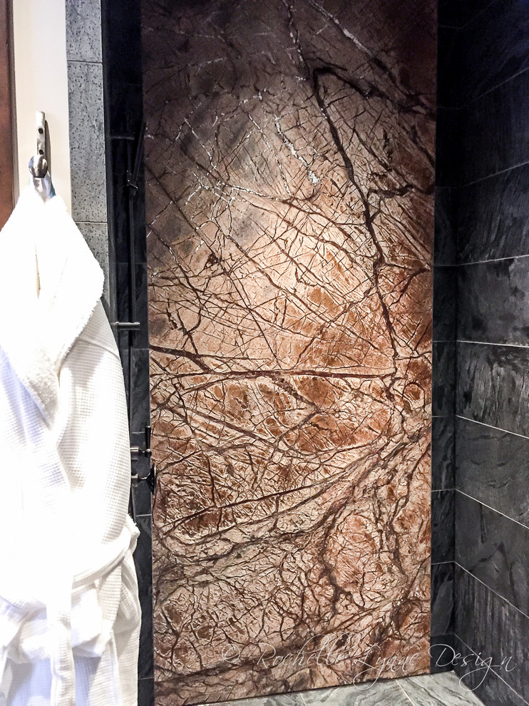 カルガリーにある巨大なラスティックスタイルのおしゃれなマスターバスルーム (バリアフリー、黒いタイル、石スラブタイル、スレートの床、ベッセル式洗面器、ガラスの洗面台) の写真