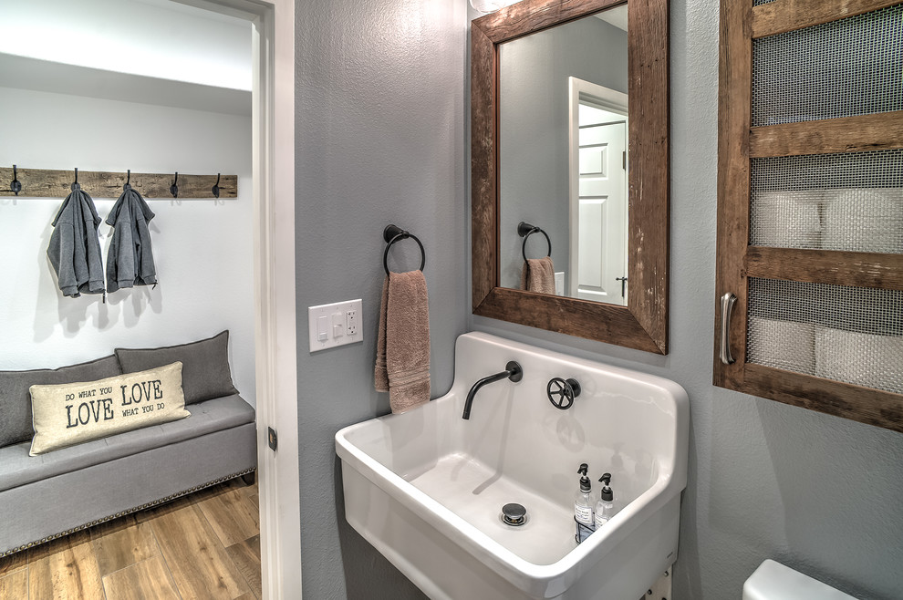 Exempel på ett litet rustikt badrum med dusch, med ett väggmonterat handfat, möbel-liknande, skåp i slitet trä, en toalettstol med separat cisternkåpa, porslinskakel, grå väggar, klinkergolv i porslin och brunt golv