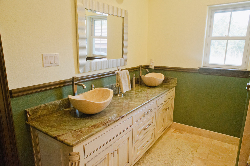 Small rustic shower room bathroom in Austin with raised-panel cabinets, distressed cabinets, a hot tub, a walk-in shower, a one-piece toilet, multi-coloured tiles, glass sheet walls, beige walls, travertine flooring, a vessel sink and granite worktops.