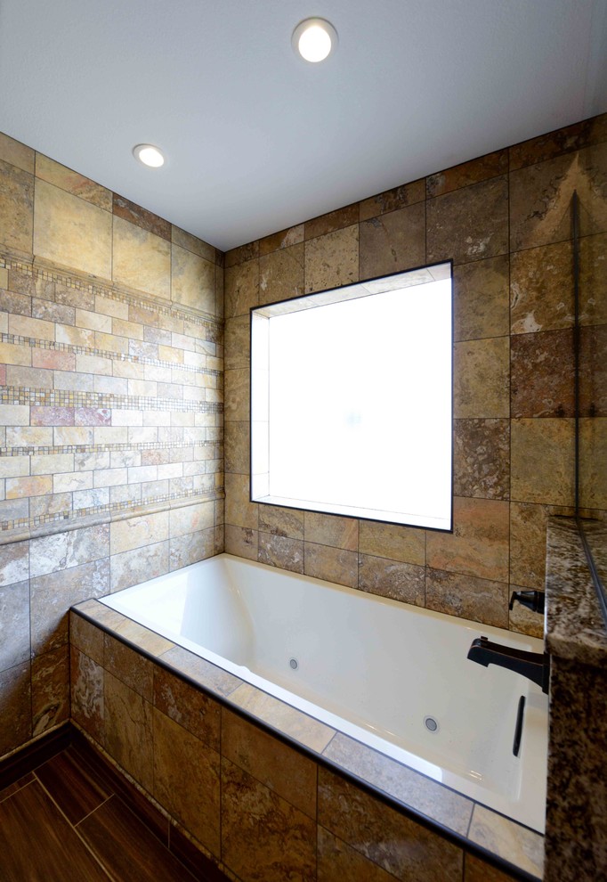 Foto på ett stort rustikt en-suite badrum, med ett badkar i en alkov, en dusch/badkar-kombination, en toalettstol med hel cisternkåpa, flerfärgad kakel, stenkakel, beige väggar, laminatgolv och granitbänkskiva