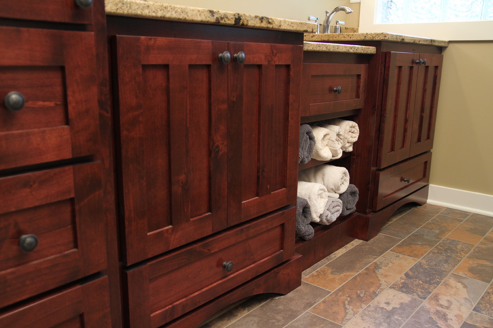 Bild på ett litet rustikt en-suite badrum, med ett undermonterad handfat, släta luckor, skåp i mellenmörkt trä, granitbänkskiva, klinkergolv i porslin, en hörndusch, porslinskakel och beige väggar