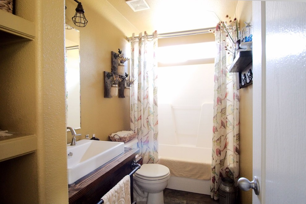Idéer för att renovera ett litet rustikt badrum, med öppna hyllor, skåp i mörkt trä, en toalettstol med separat cisternkåpa, gula väggar, skiffergolv, ett fristående handfat, träbänkskiva och grått golv