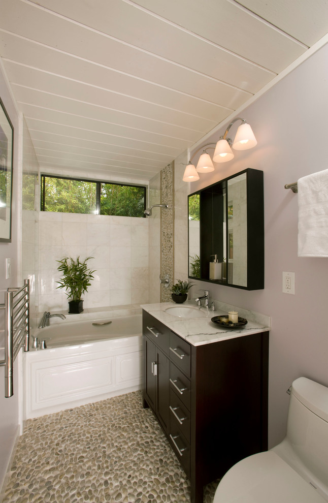 Идея дизайна: маленькая детская ванная комната в стиле неоклассика (современная классика) с фасадами в стиле шейкер, черными фасадами, ванной в нише, душем над ванной, унитазом-моноблоком, белой плиткой, керамогранитной плиткой, белыми стенами, полом из галечной плитки, врезной раковиной, мраморной столешницей, серым полом, шторкой для ванной, тумбой под одну раковину, напольной тумбой, потолком из вагонки и фиолетовой столешницей для на участке и в саду