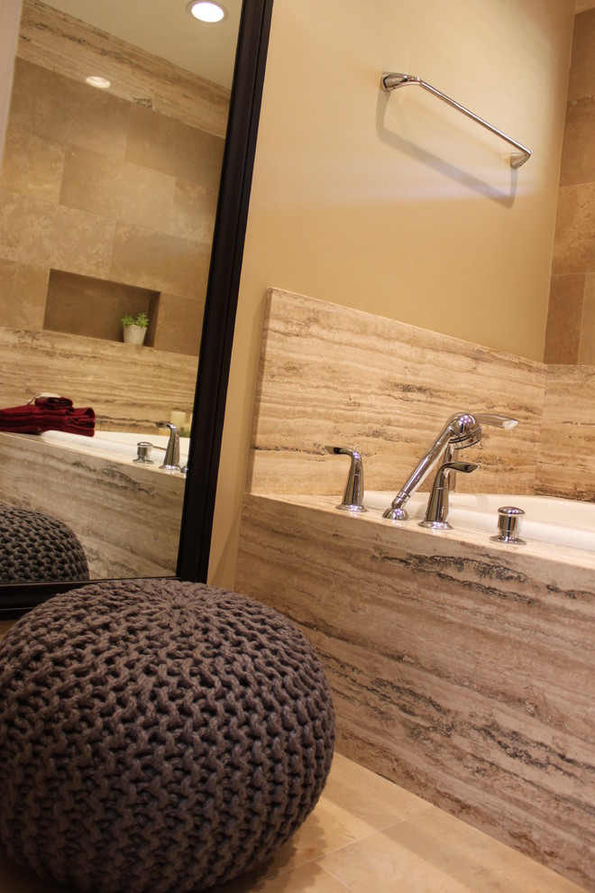 Exemple d'une douche en alcôve principale chic en bois foncé de taille moyenne avec un placard à porte plane, une baignoire posée, WC à poser, un carrelage beige, un carrelage de pierre, un mur beige et un lavabo encastré.