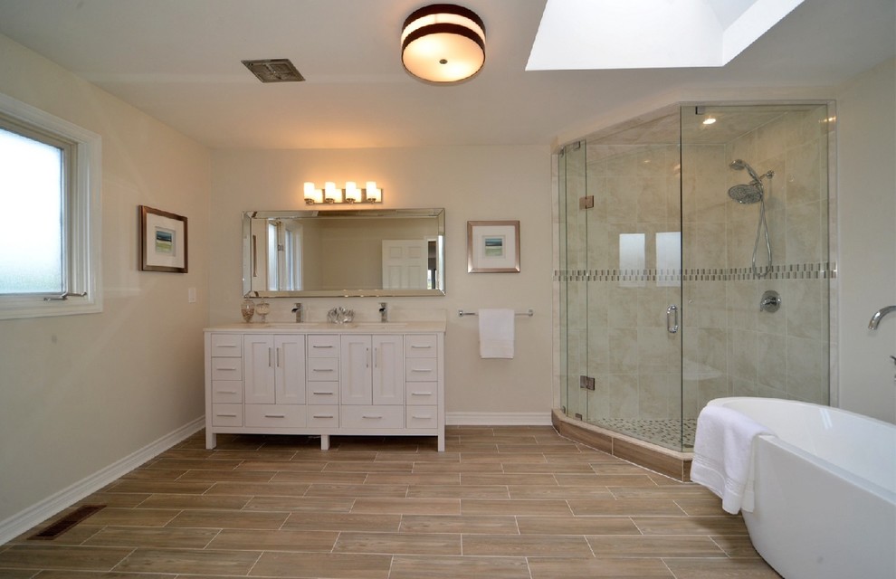 Idéer för ett stort klassiskt en-suite badrum, med ett fristående badkar, en hörndusch, keramikplattor, ett undermonterad handfat, skåp i shakerstil, vita skåp, beige kakel, beige väggar, klinkergolv i porslin, brunt golv och dusch med gångjärnsdörr