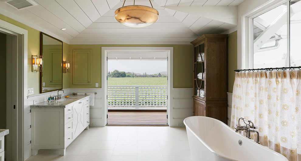 Imagen de cuarto de baño tradicional con bañera exenta y paredes verdes