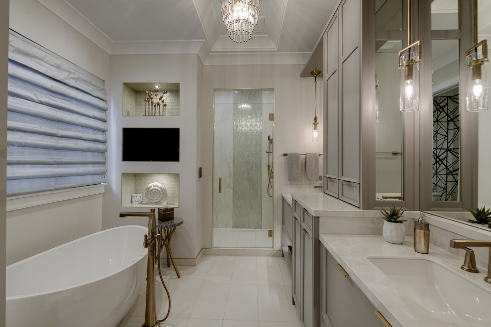 Photo of a classic ensuite bathroom in Chicago with recessed-panel cabinets, grey cabinets, a freestanding bath, an alcove shower, beige walls, an integrated sink, beige floors, a hinged door, white worktops, double sinks, a built in vanity unit and a coffered ceiling.