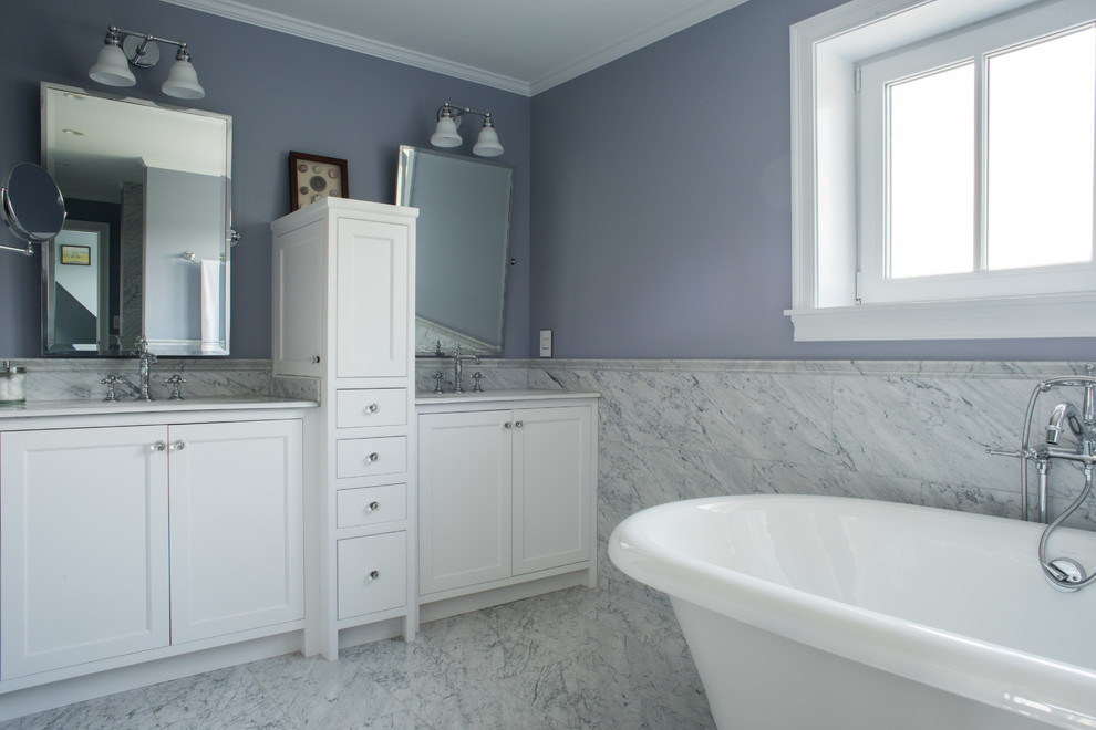 Foto de cuarto de baño principal tradicional renovado con puertas de armario blancas, encimera de mármol, bañera exenta, paredes púrpuras y suelo de mármol