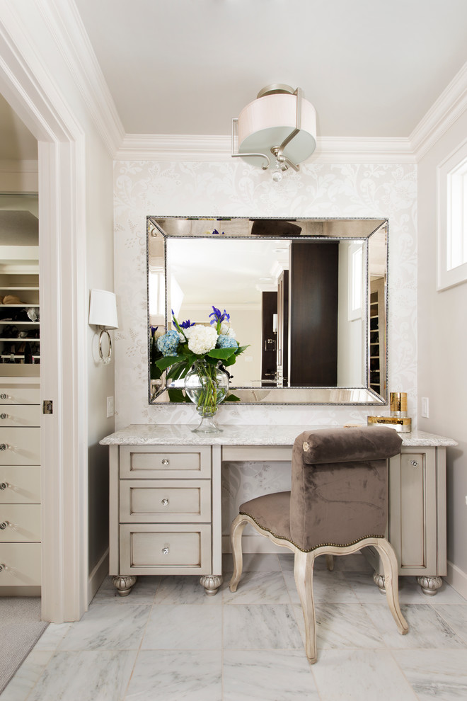 Inredning av ett klassiskt stort en-suite badrum, med grå skåp, ett fristående badkar, vit kakel, stenkakel, grå väggar, marmorgolv, bänkskiva i kvarts, luckor med profilerade fronter och vitt golv