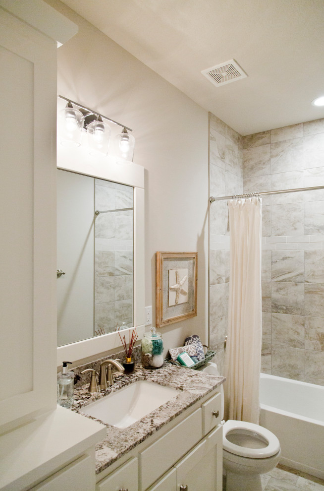 Example of a mid-sized minimalist master multicolored tile and ceramic tile ceramic tile, brown floor and single-sink bathroom design in Kansas City with recessed-panel cabinets, white cabinets, beige walls, an undermount sink, granite countertops, multicolored countertops and a built-in vanity