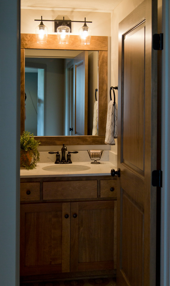 Ejemplo de cuarto de baño rústico de tamaño medio con puertas de armario de madera oscura, paredes beige, aseo y ducha, armarios estilo shaker, lavabo bajoencimera y encimeras blancas