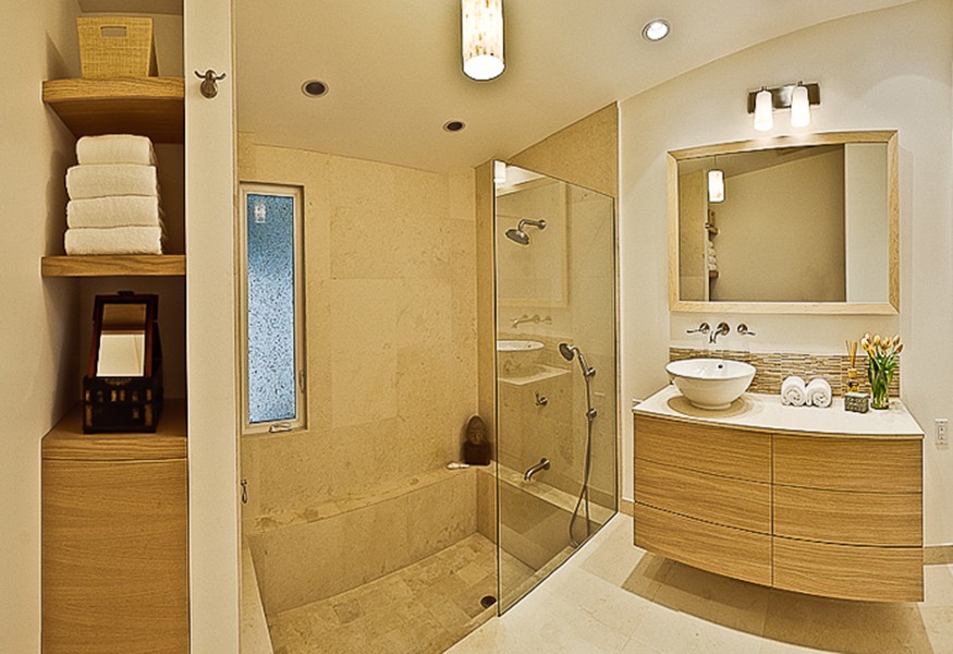 Idéer för att renovera ett funkis en-suite badrum, med ett fristående handfat, släta luckor, skåp i ljust trä, bänkskiva i kalksten, ett platsbyggt badkar, en dusch/badkar-kombination, beige kakel, stenkakel, vita väggar och kalkstensgolv