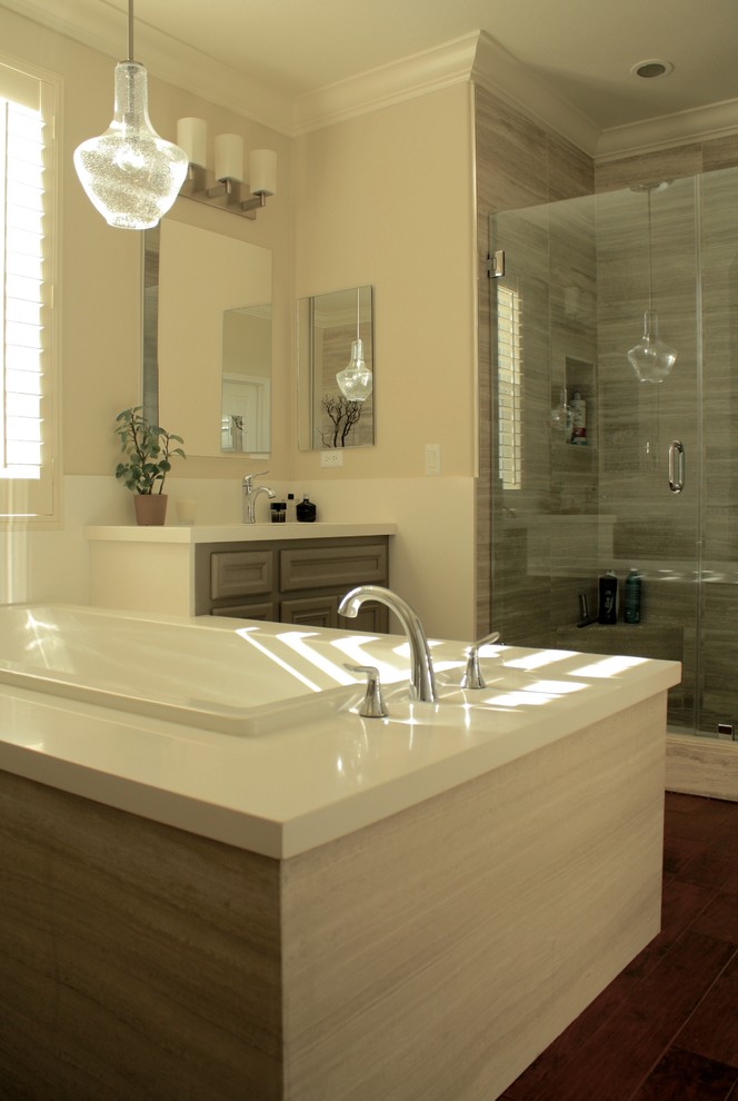 Bild på ett mellanstort funkis en-suite badrum, med luckor med upphöjd panel, grå skåp, bänkskiva i kvartsit, ett platsbyggt badkar, en dusch i en alkov, brun kakel, keramikplattor, bruna väggar, mörkt trägolv, brunt golv och dusch med gångjärnsdörr