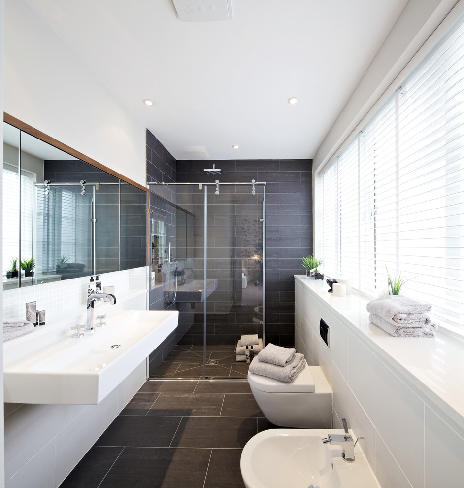 Immagine di una stanza da bagno contemporanea con doccia a filo pavimento e piastrelle grigie