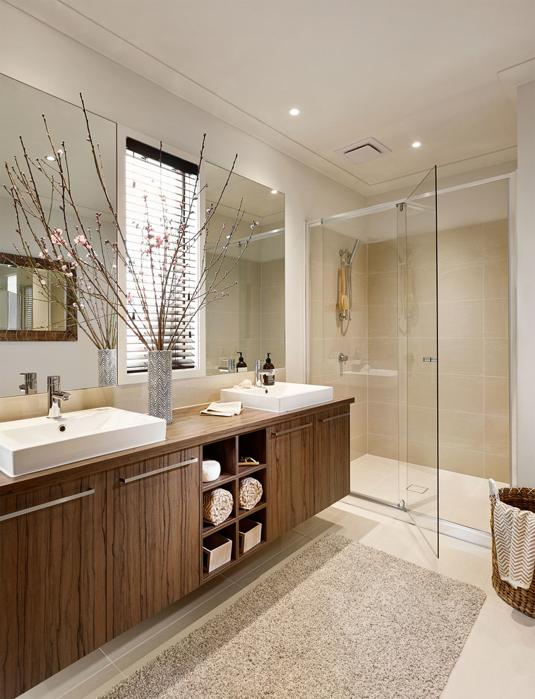 Bild på ett funkis badrum, med släta luckor, skåp i mörkt trä, en dusch i en alkov, beige kakel, vita väggar och dusch med gångjärnsdörr