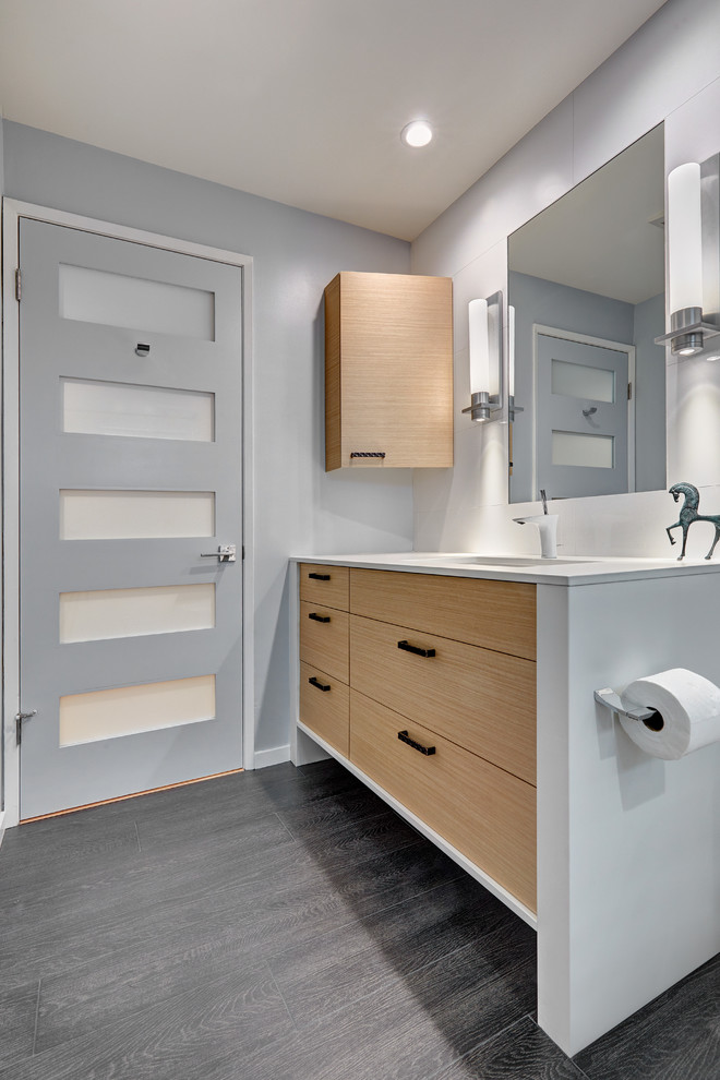 Photo of a medium sized contemporary ensuite bathroom in Sacramento with flat-panel cabinets, light wood cabinets, a double shower, a one-piece toilet, white tiles, porcelain tiles, white walls, porcelain flooring, a submerged sink and engineered stone worktops.